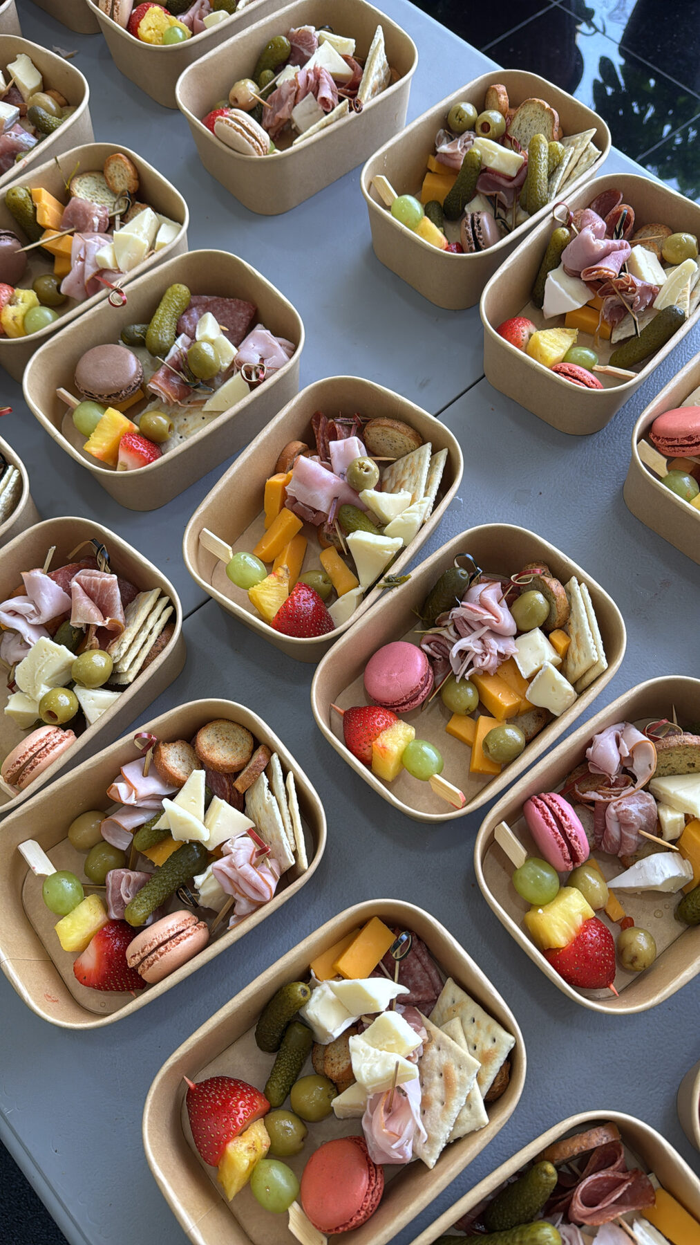 Individual charcuterie boxes lined up for a corporate order.