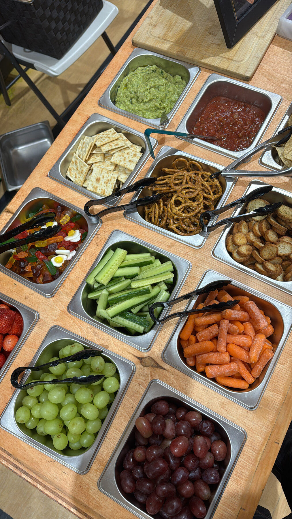 A grazing station with fruit, veggies, gummies, and dips.