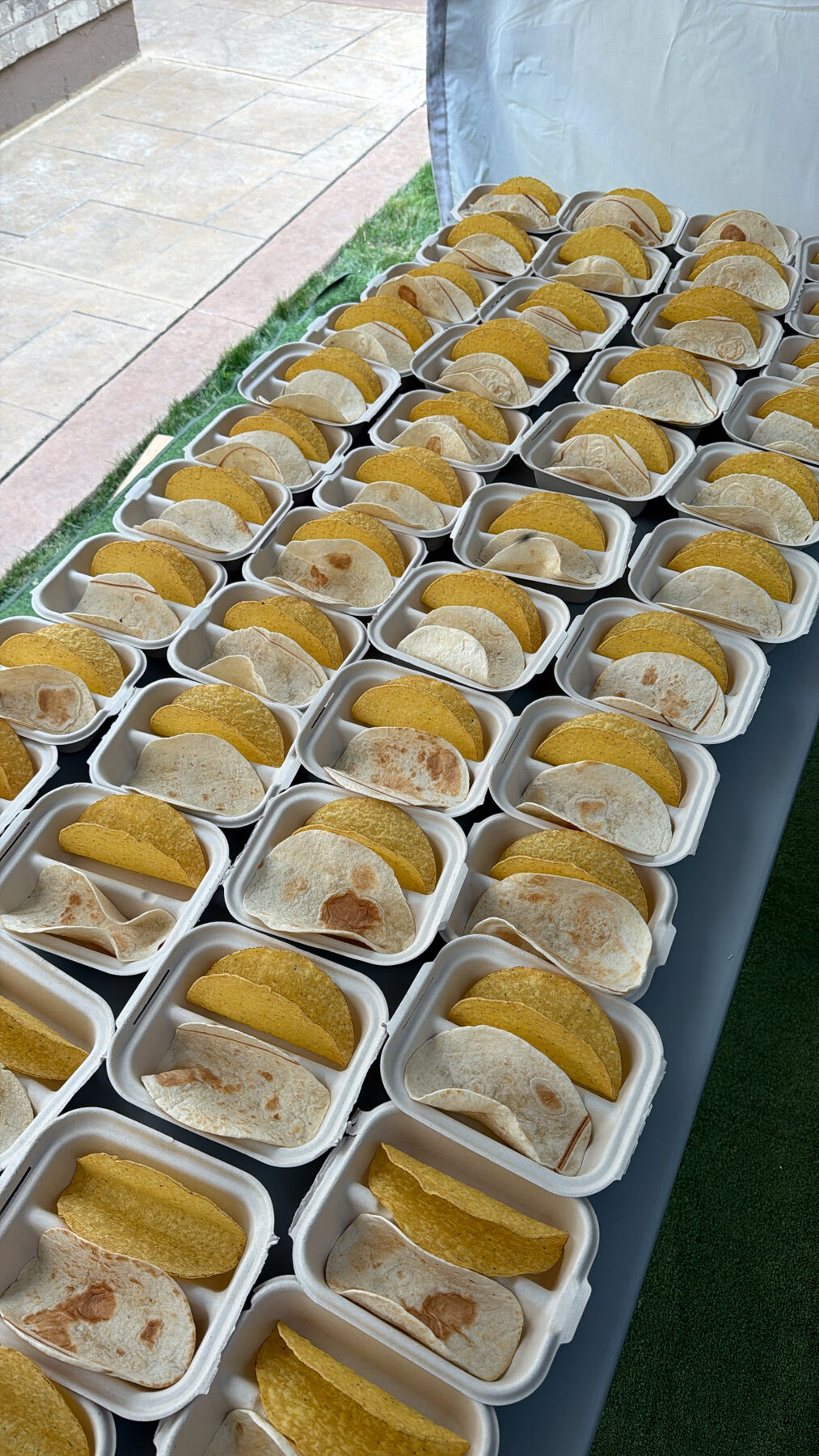 Rows of taco boxes with hard and soft shells, ready to serve.