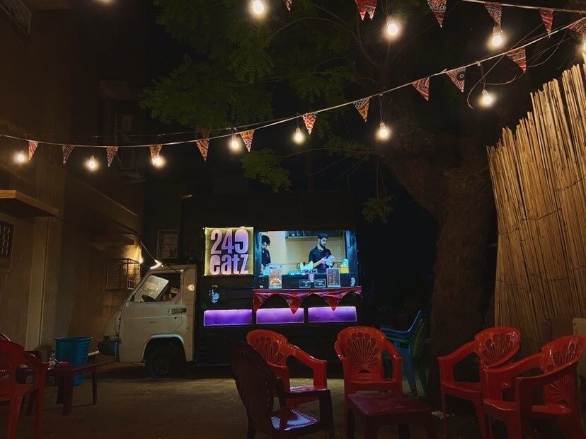 The 249 Eatz truck glowing at night with string lights and festival bunting.