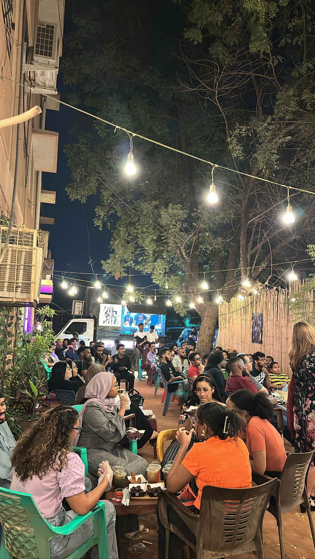 A packed night crowd under string lights at the 249 Eatz food truck in Khartoum.